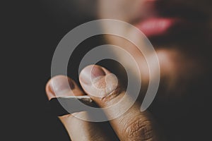 A man smokes cannabis weed, a joint and a lighter in his hands. Smoke on a black background. Concepts of medical marijuana