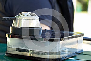 A man smokes a hookah on a mountain in Bukovel in the summer in the sun at the table, smoking a hookah