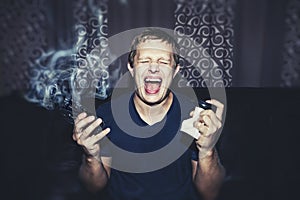 Man with a smoking broken phone and crumpled coffee Cup