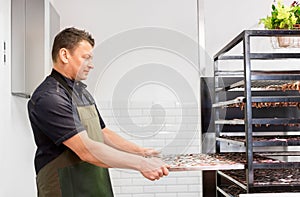 Man with smoking tray at fish shop or smokehouse