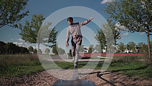 Man in sneakers learns walk and balance on balancing rope from rubber in a park in Germany. Sport, leisure, recreation