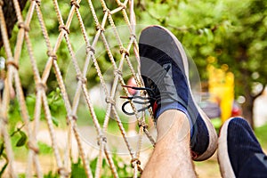 Man In Sneakers Lying In Hammock In Woods