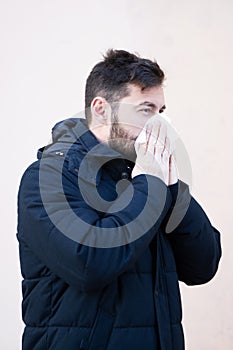 Man sneezing outside in winter