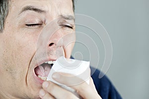 Man Sneezing Into Tissue