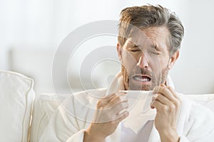 Man Sneezing Into Tissue