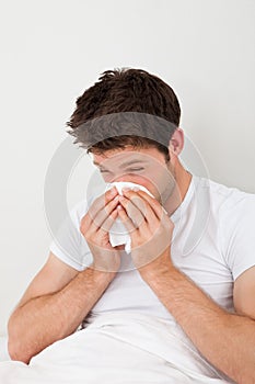 Man Sneezing Into A Tissue