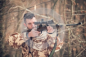 Man with a sniper and shooting on an open season, looking through scope