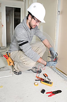 Man snipping wall wiring