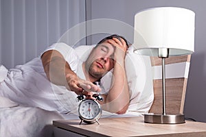 Man snoozing alarm clock photo