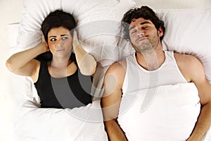 Man snoring keeping woman awake in bed