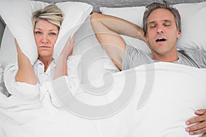 Man snoring loudly as partner blocks her ears