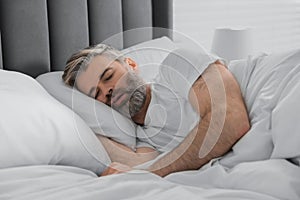 Man snoring while sleeping in bed at home