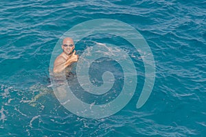 Man with snorkel mask tuba and snorkel in sea. Snorkeling, swimming, vacation. Tourists are engaged in snorkeling in the