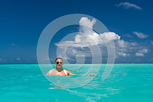 Man snorkeling in clear tropical waters in front of exotic island