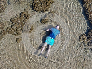 Man snorkeling in coral reef in tropical transparent sea