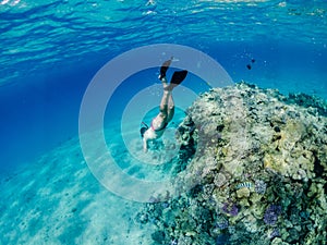 Man snorkeling and freediving near the coral reef edge in Red Sea