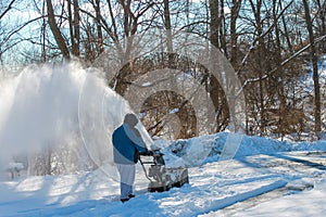 Man snow blowing his driveway.