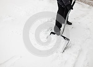 Man with snow shovel cleans sidewalks photo