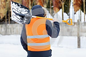 Man with snow shovel near tanks in winter