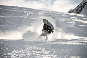 Man on a snowboard gliding on a snowy mountain