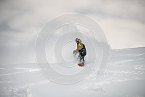 Man on a snowboard slipping on a snowy mountain