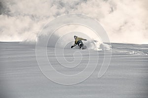 Man on a snowboard slipping on a snowy mountain side