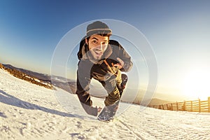 Man snowboarder playful jump trick
