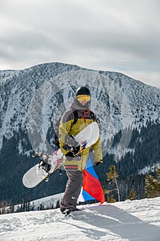 Man snowboarder with slovakia flag at ski resort slope