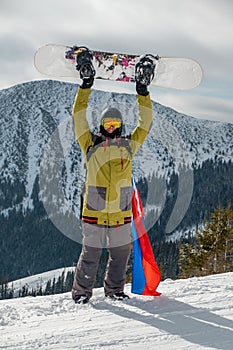 Man snowboarder with slovakia flag at ski resort slope