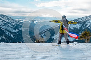 Man snowboarder with slovakia flag at ski resort slope