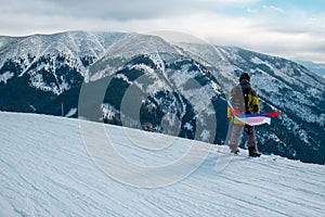 Man snowboarder with slovakia flag at ski resort slope