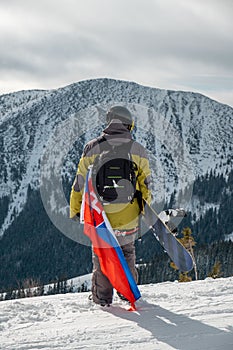 Muž snowboardista so slovenskou vlajkou na svahu lyžiarskeho strediska