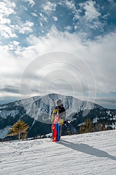 Muž snowboardista se slovenskou vlajkou na svahu lyžařského střediska