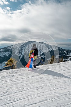 Muž snowboardista so slovenskou vlajkou na svahu lyžiarskeho strediska