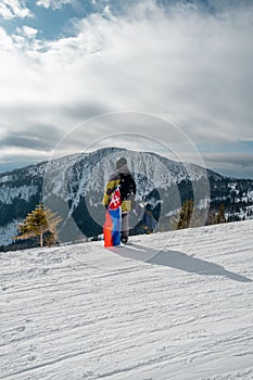 Man snowboarder with slovakia flag at ski resort slope