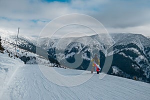 Muž snowboardista se slovenskou vlajkou na svahu lyžařského střediska