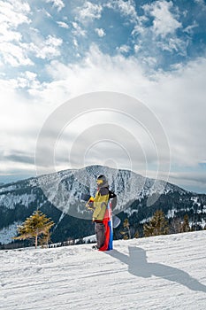 Man snowboarder with slovakia flag at ski resort slope