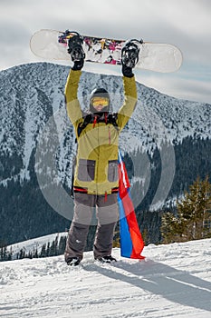 Man snowboarder with slovakia flag at ski resort slope