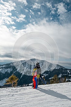 Man snowboarder with slovakia flag at ski resort slope