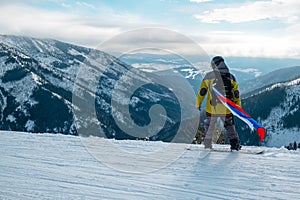 Man snowboarder with slovakia flag at ski resort slope