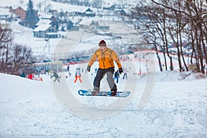 man snowboarding down by hill