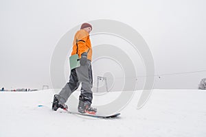 man snowboarding down by hill