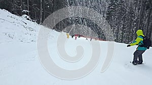 man snowboarding down by slope