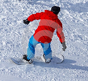 A man snowboarding a mountain in the snow in winter