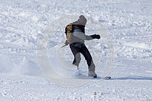 A man snowboarding a mountain in the snow in winter