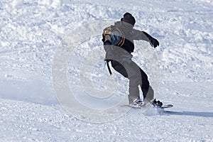 A man snowboarding a mountain in the snow in winter