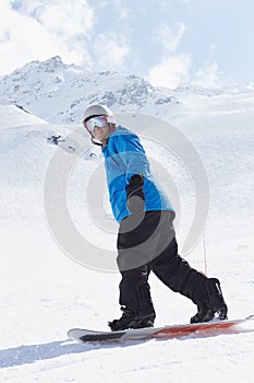 Man Snowboarding On Ski Holiday In Mountains