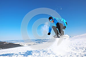 Man snowboarding on snowy hill. Winter vacation
