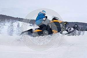 Man on snowmobile in winter mountain photo