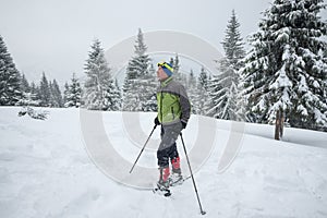 Man in snowshoes enjoying life while traveling in the winter mountains